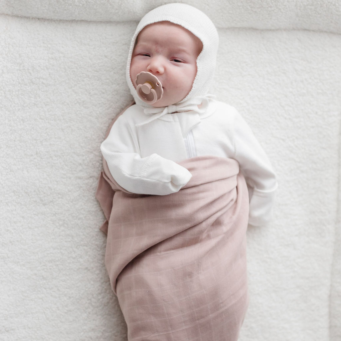 Baby wearing Muslin Swaddle Blanket | Sunset (Organic)