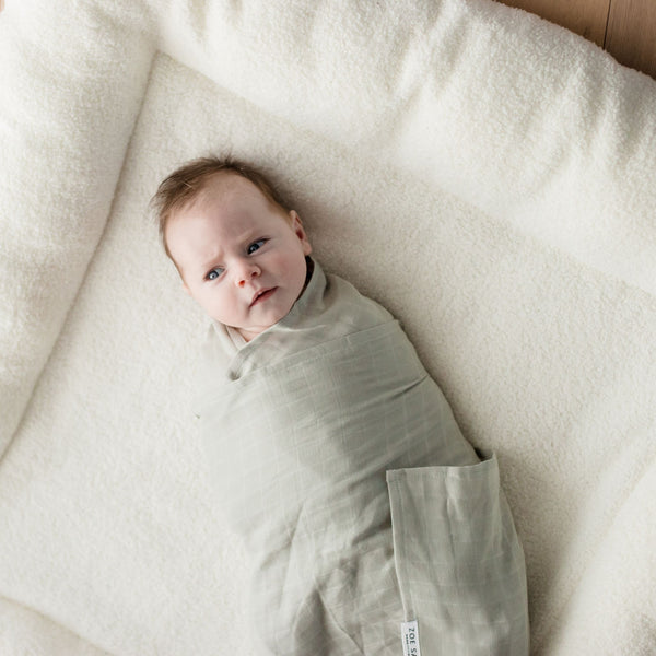 Baby wearing Muslin Swaddle Blanket | Sage Green (Organic)