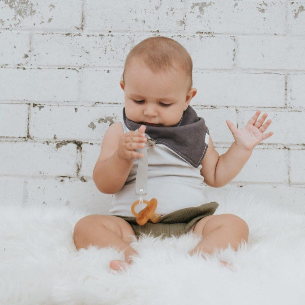 Baby wearing Linen Dribble Bib in gray color