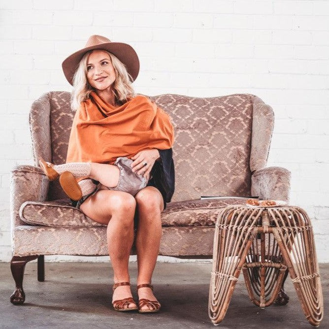 Women sitting on the sofa while feeding her baby